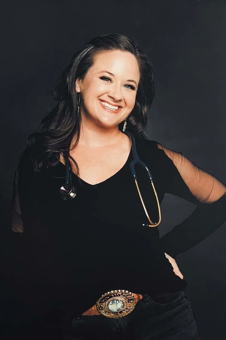 Smiling healthcare professional in black with stethoscope and decorative belt buckle