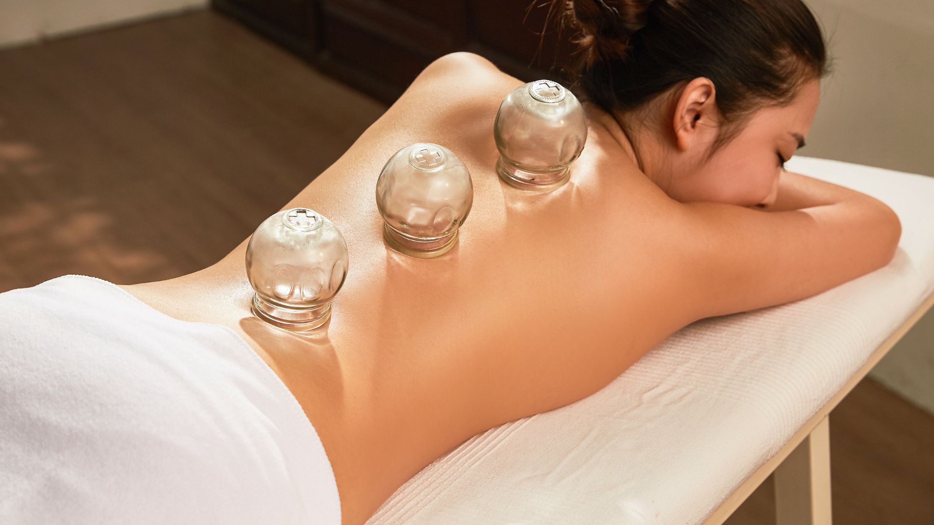 Cupping therapy treatment with glass cups on person's back during massage